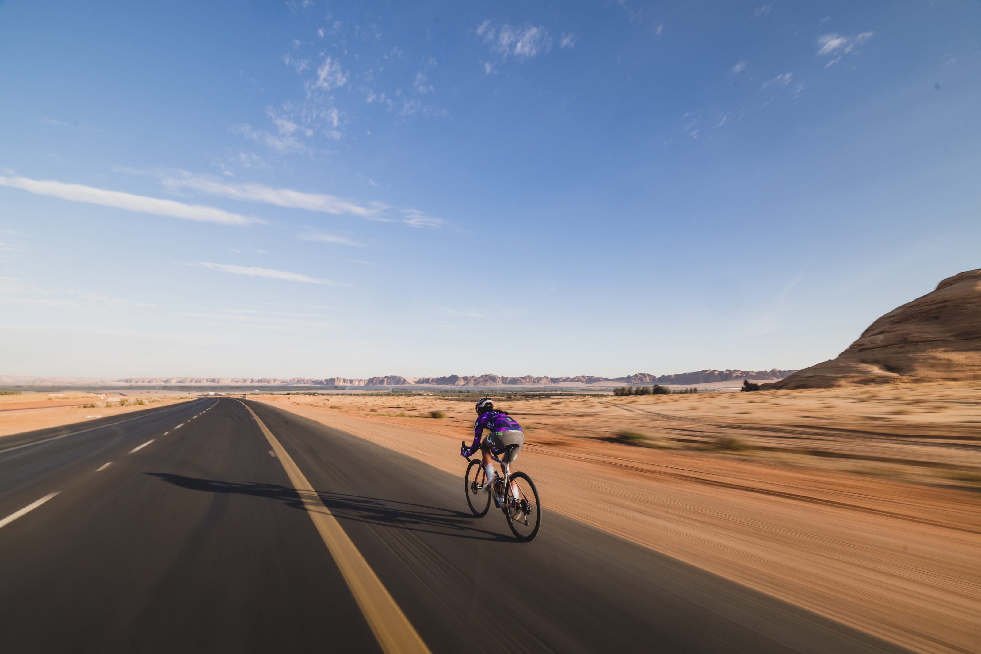 Moroj Adil riding an open desert road in AlUla