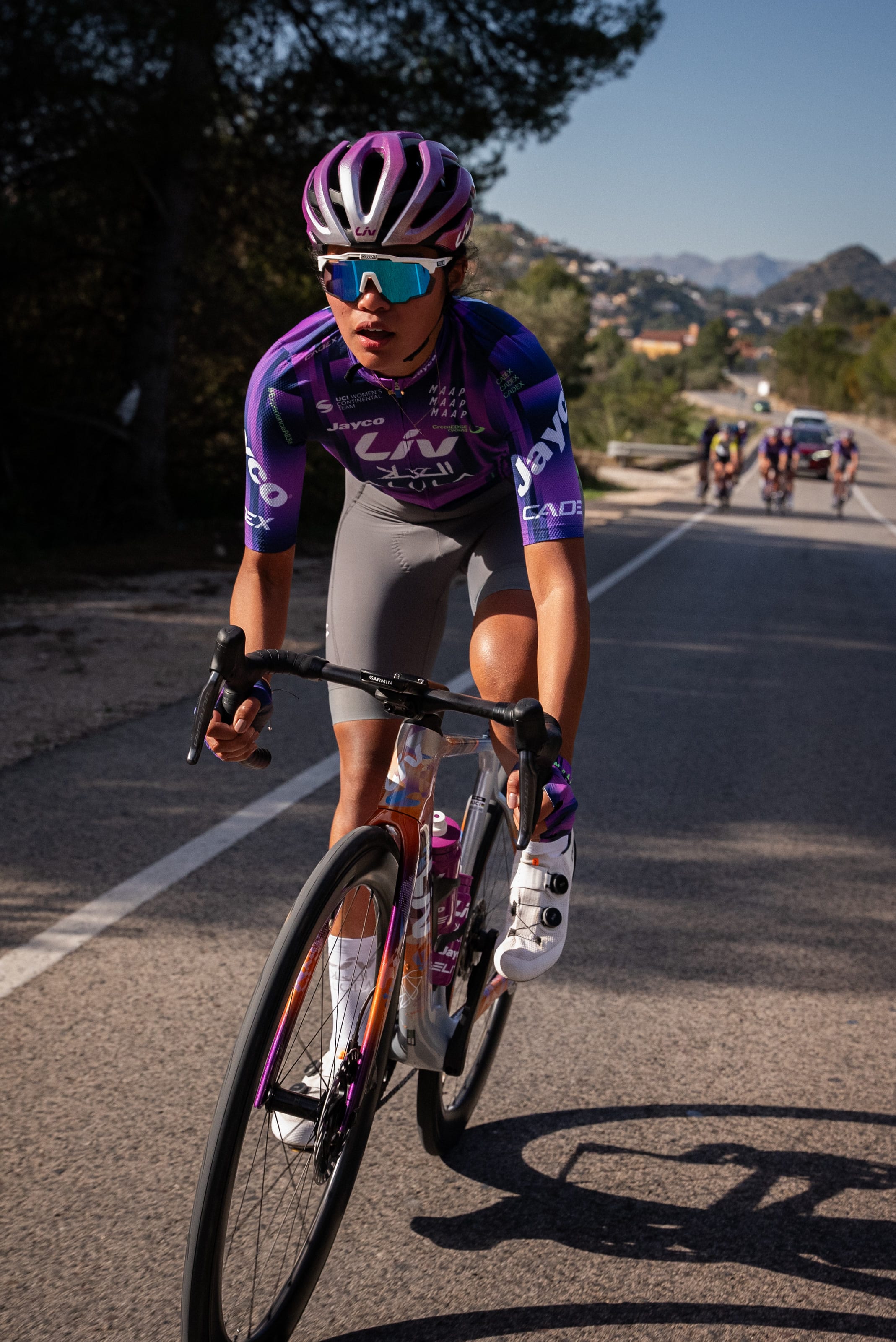 Moroj Adil riding at the front on a European road, the rest of the group behind her