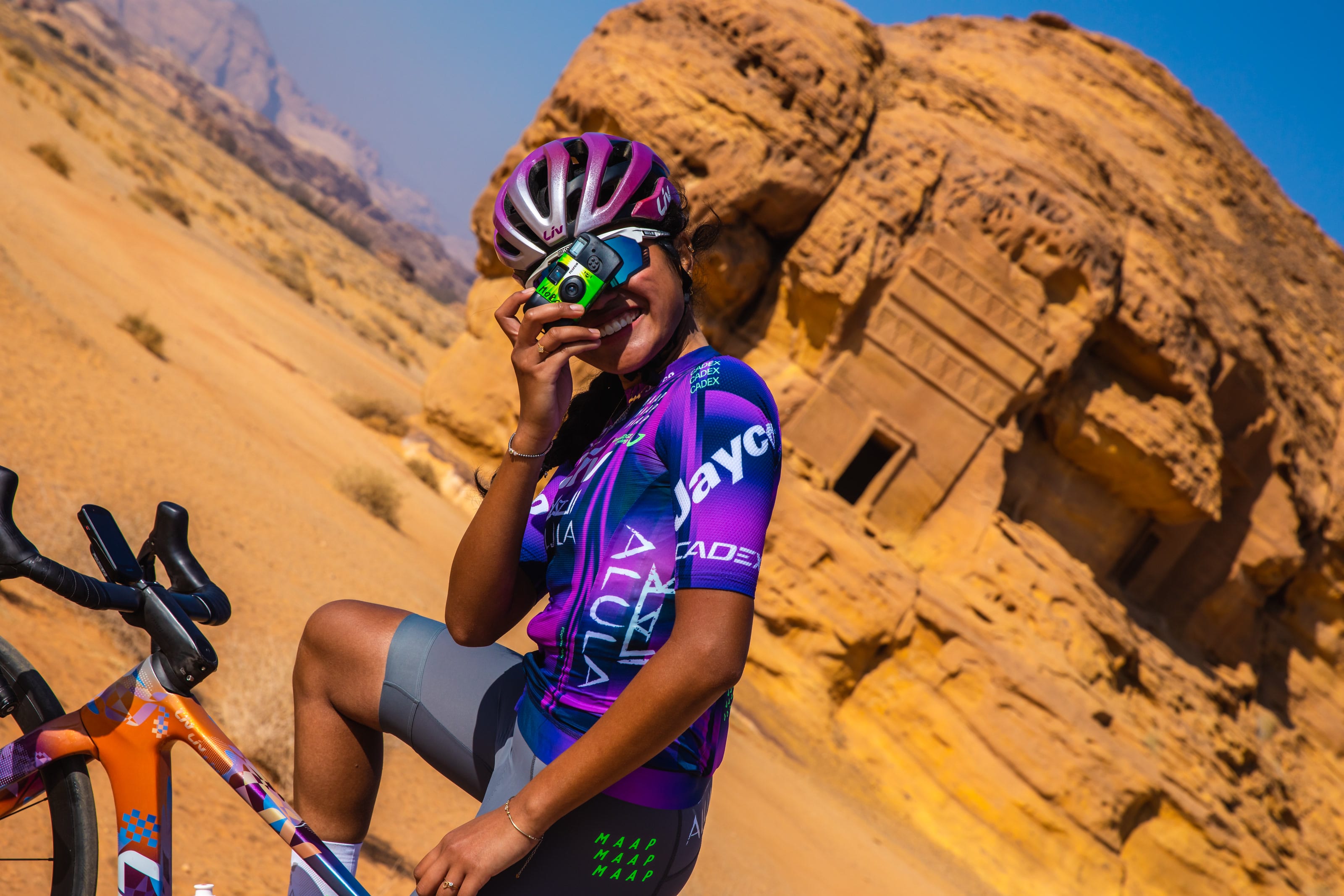 Moroj Adil pausing beside a carved rock facade in AlUla
